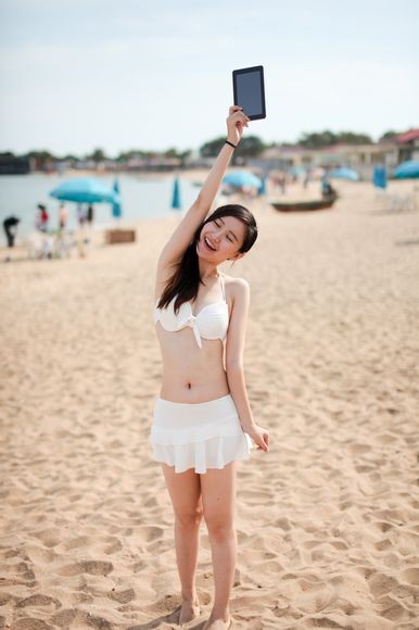 Hotgirl diện bikini nóng bỏng dạo biển cùng tablet
