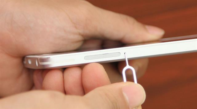Dùng cây chọt SIM chuyên dụng để đẩy khay SIM ra