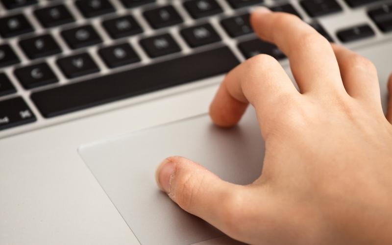 Một ngón tay nhấn trackpad và một ngón tay di chuyển