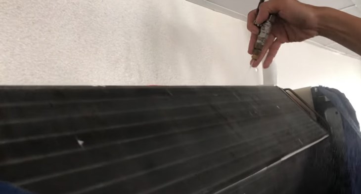 Dùng vòi xịt nước để loại bỏ bụi bẩn bám trên các bộ phận bên trong máy lạnh