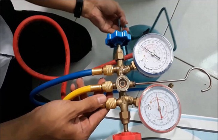 Kỹ thuật viên nạp ga R410A vào máy lạnh sử dụng đồng hồ đo áp suất