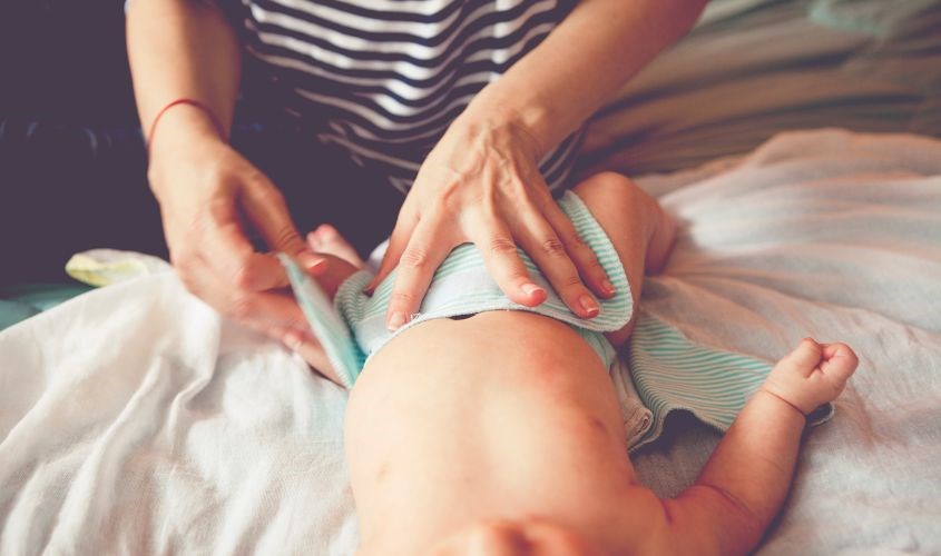 Mẹ cố định tã vải bằng cách dán hai bên Mẹ cố định tã vải bằng cách dán hai bên