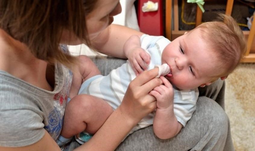 Giữ bé cố định trong khi rơ lưỡi