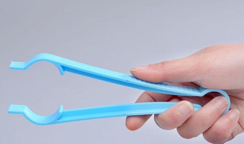 Dùng chiếc kẹp gắp có sẵn để đưa các vật dụng ra ngoài