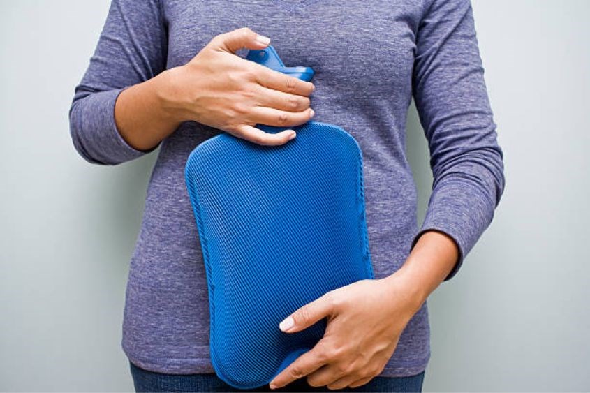 Chườm bụng với nước ấm giúp bụng nhỏ bất ngờ. Ảnh: iStock