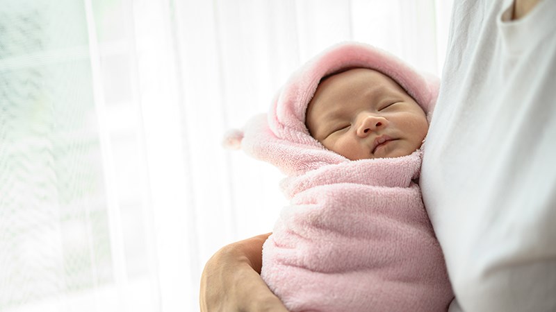 Thay vì mặc quần áo quá dày hoặc đắp chăn, hãy quấn khăn để giữ ấm cho trẻ sơ sinh khi ngủ.