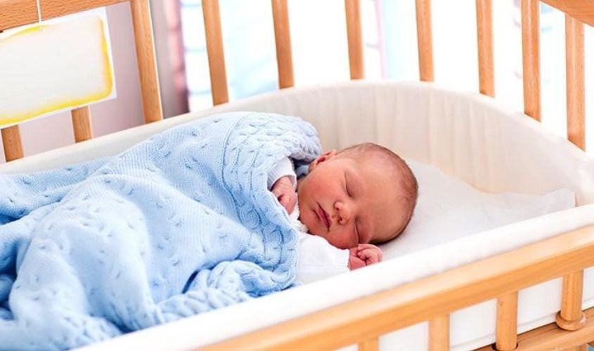 Nên để bé nằm nghiêng trong nôi, cũi  của mình và đặt ngay cạnh giường cha mẹ