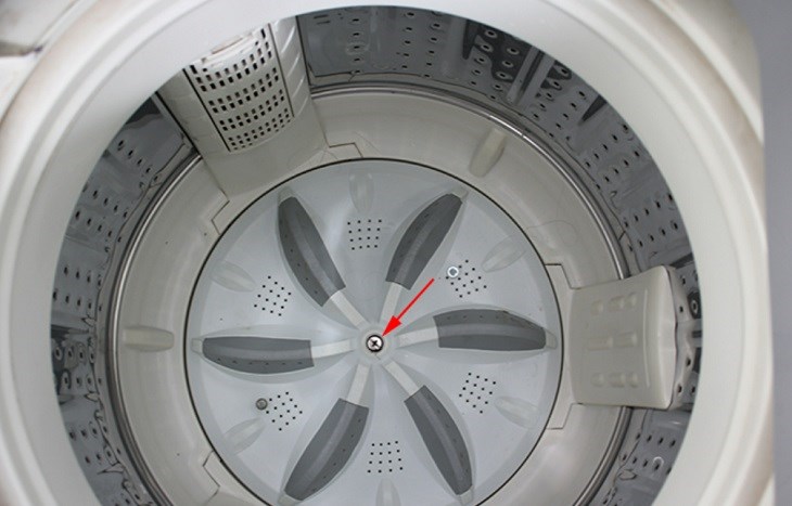bạn tiếp tục dùng tua-vit để tháo ốc vít cố định mâm giặt với lồng giặt, và tiến hành nhấc lồng giặt ra khỏi máy giặt