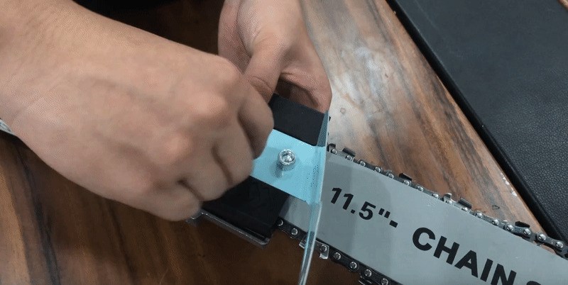 Siết chặt 2 bulong dài bằng lục giác sau khi đã căng lưỡi cưa