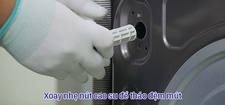 Xoay nhẹ nút cao su và tháo bu lông ra