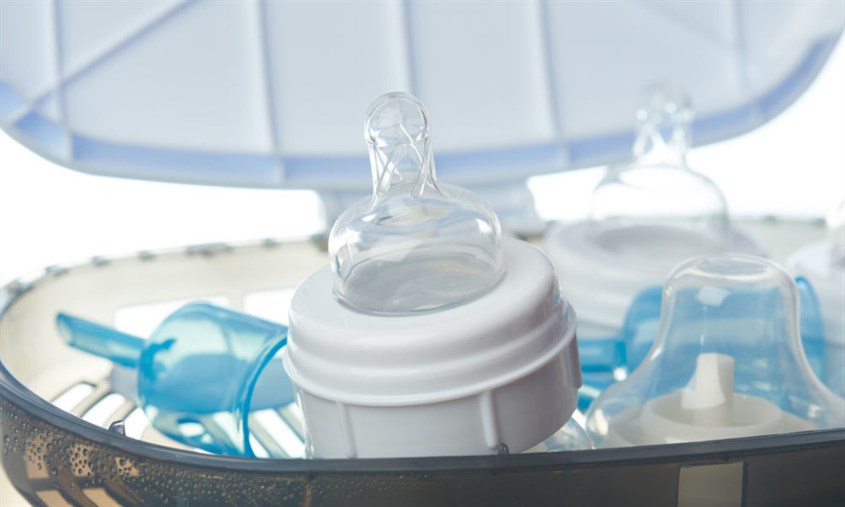 Đặt bình sữa và các bộ phận của bình vào máy và đóng chặt nắp máy 