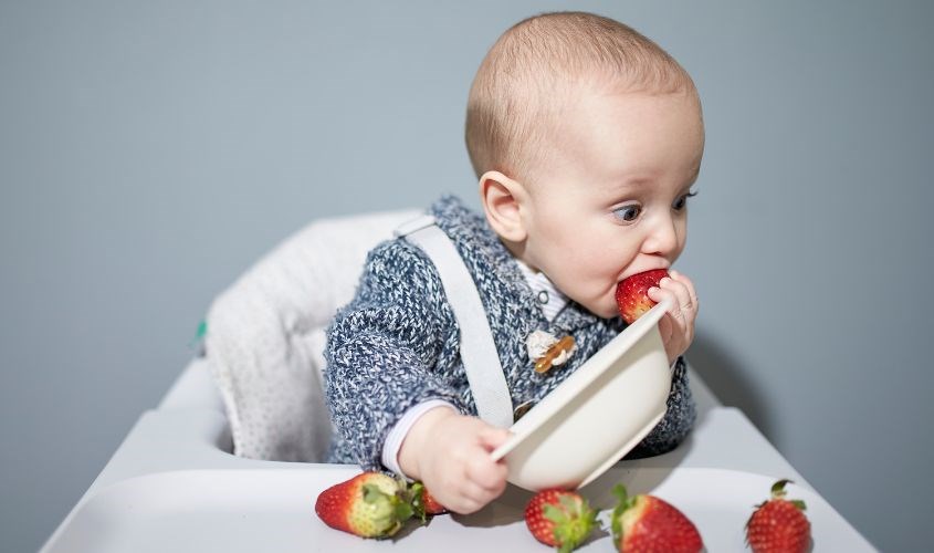 Bé ngả người về phía trước khi thấy đồ ăn