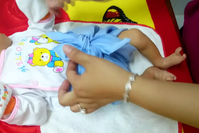 Mẹ nhớ cố định tã vải cho bé chắc chắn để bé thoải mái vận động nhé