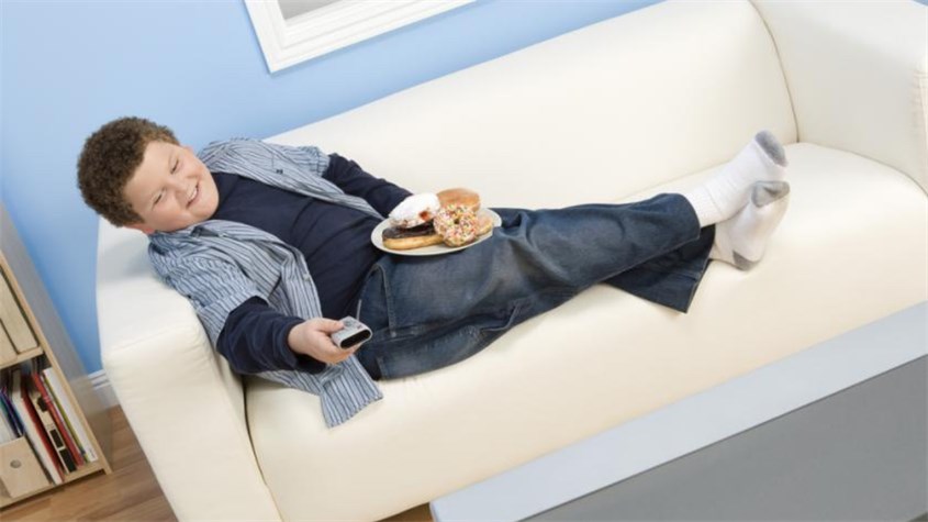 Bé thường có thói quen ăn nhiều hơn và ăn vặt hơn khi xem các chương trình trên TV. Nguồn ảnh: Medical Daily