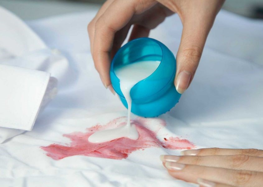 Lấy một ít nước tẩy, bôi vào vết bẩn trên quần áo của trẻ và chờ trong vài phút. Nguồn từ hellolaundry
