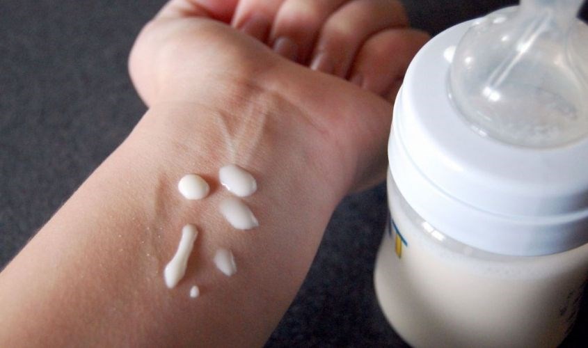 Nhỏ giọt sữa lên tay để kiểm tra nhiệt độ trước khi cho bé uống