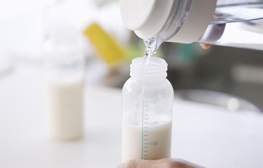 Đổ 180 ml nước ấm 40 độ C vào bình sữa có chia vạch sẵn