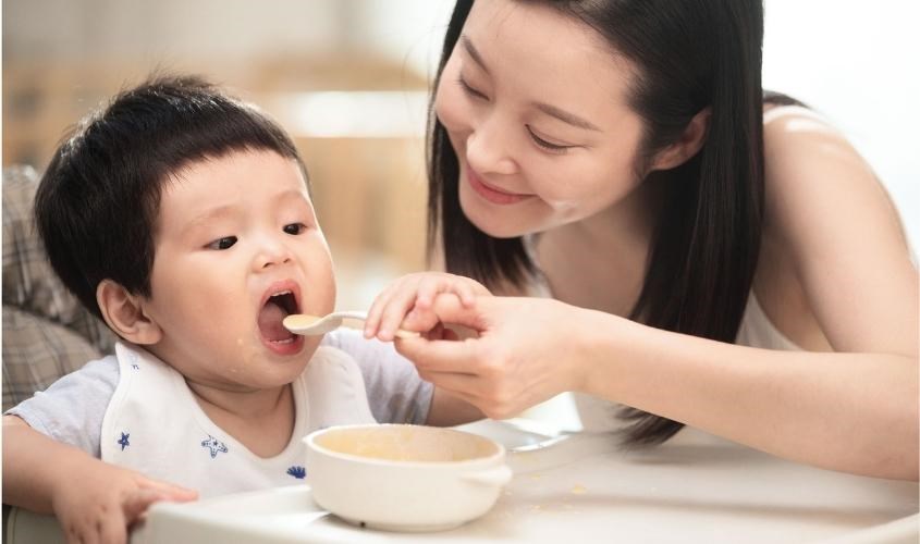Bố mẹ hỗ trợ cho con làm quen với thìa