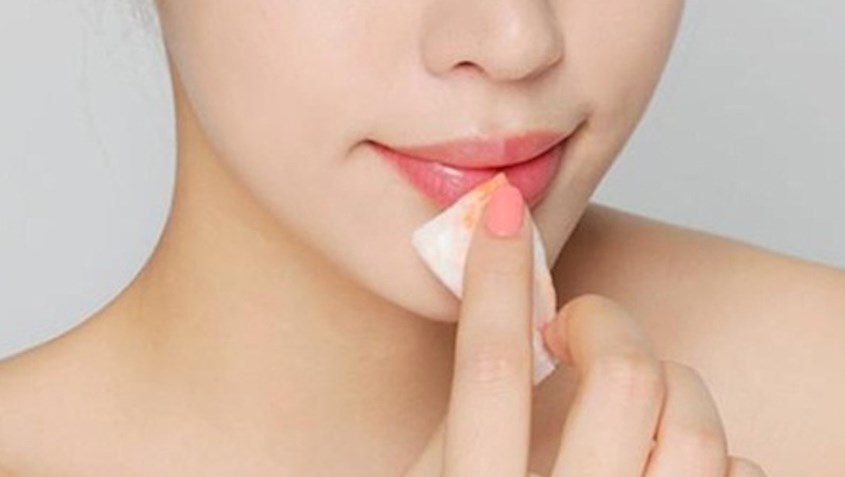 dùng bông tẩy trang lau sạch tẩy tế bào chết trên môi