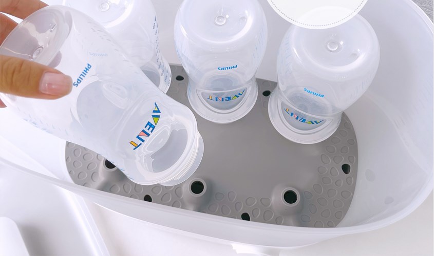 Xếp bình sữa và dụng cụ cần tiệt trùng vào máy