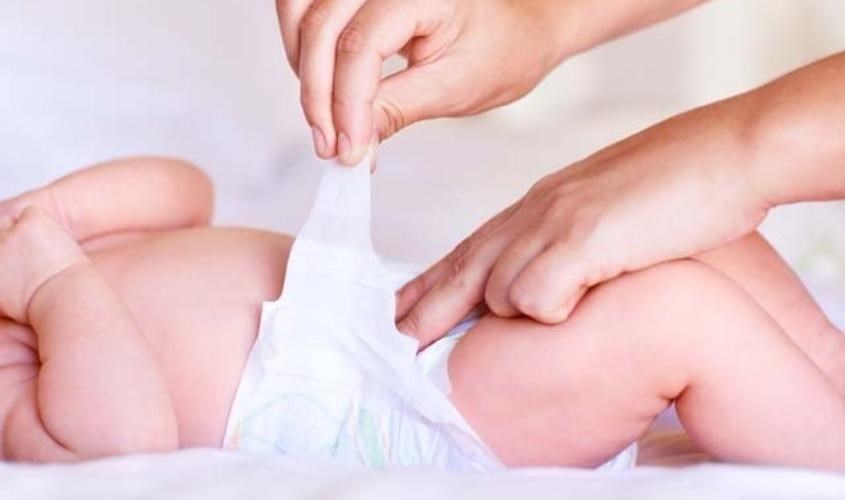 Căn chỉnh và cố định miếng dán hai bên của tã