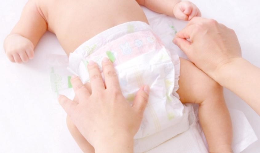 Gỡ miếng dán cố định hai bên để tháo tã cũ