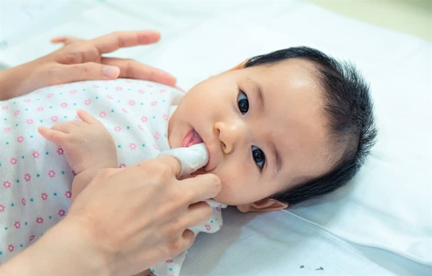 Vệ sinh nướu theo hình tròn và không nên cho ngón tay quá sâu vào họng bé