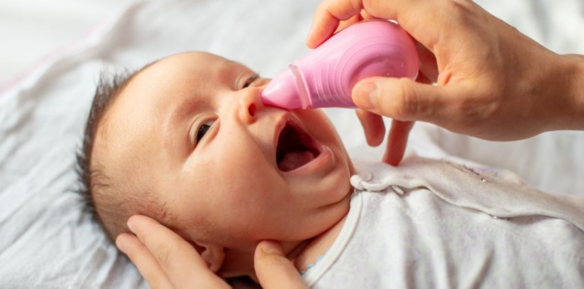 Đặt bé nằm xuống đầu hơi ngửa về phía sau