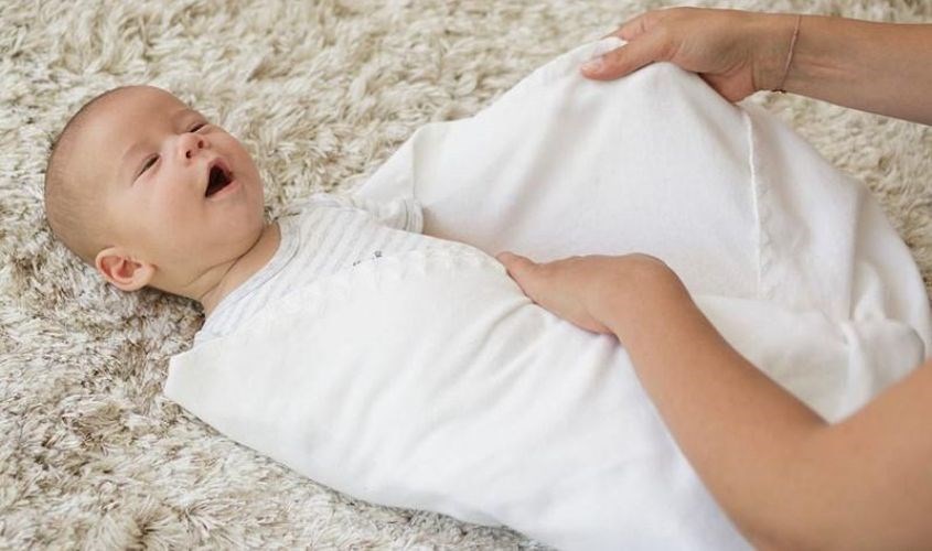 Gập phần khăn còn lại để bao bọc cơ thể bé