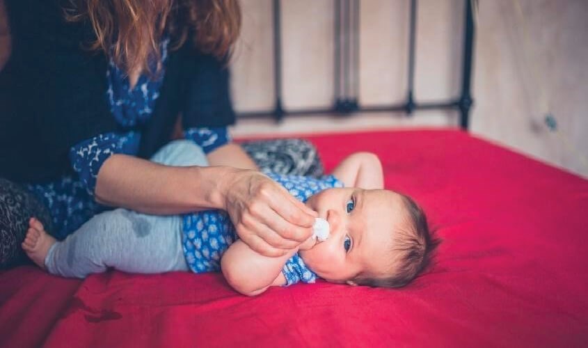 đặt đầu ống vào sát mũi bé, nhỏ từng giọt nước muối vào mũi bé