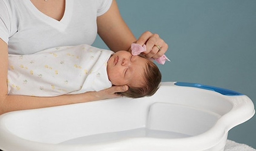 Dùng khăn nhẹ nhàng lau mặt, mắt và tai cho bé