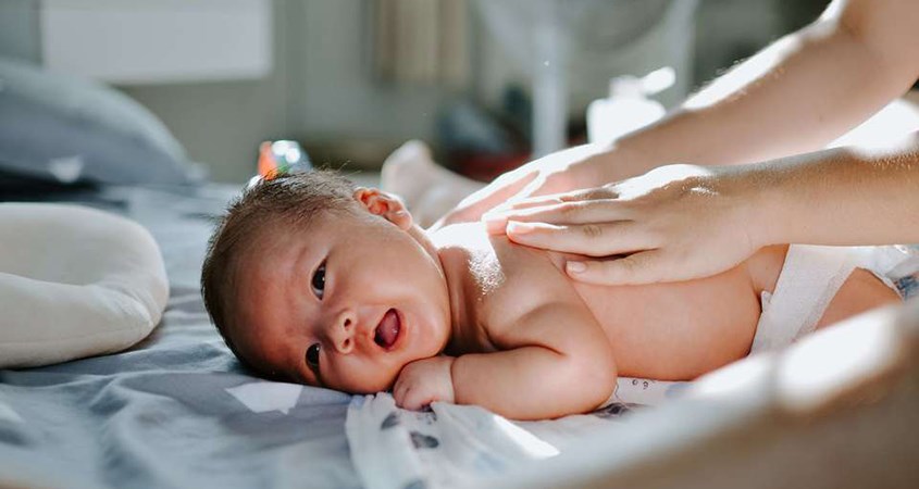 Sau khi làm sạch, thoa phấn rôm cho bé