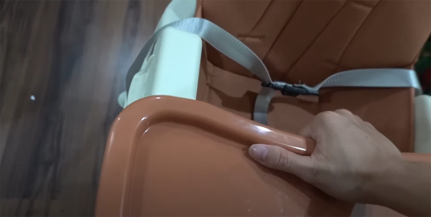 Lấy khay ăn và lắp vào phần trên của ghế