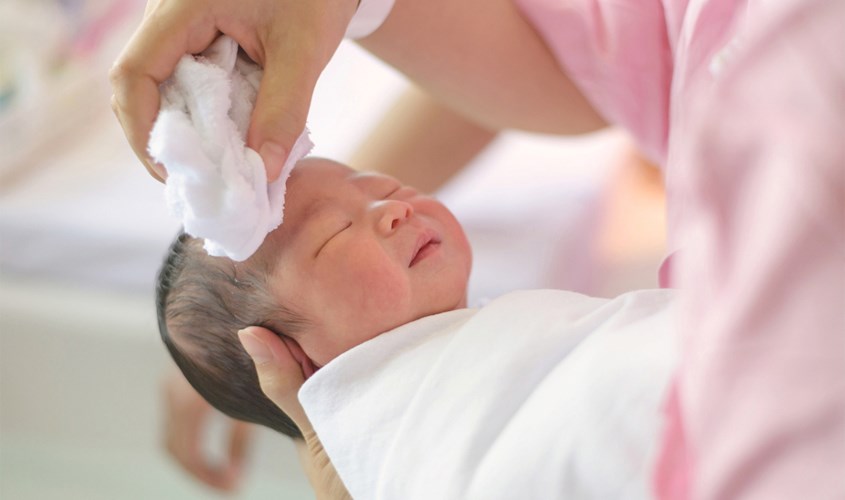 Mẹ hãy massage nhẹ nhàng da đầu của con bằng khăn để loại bỏ sạch vảy trên da