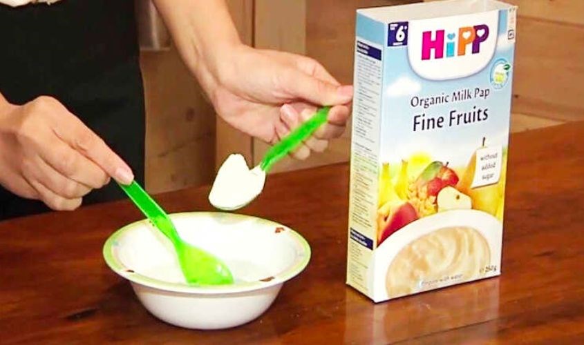 Đong khoảng 3 - 4 thìa bột ăn dặm HiPP cho khẩu phần ăn của trẻ 4 tháng tuổi