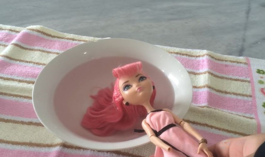 Nhúng tóc búp bê vào nước cho tóc ướt đều