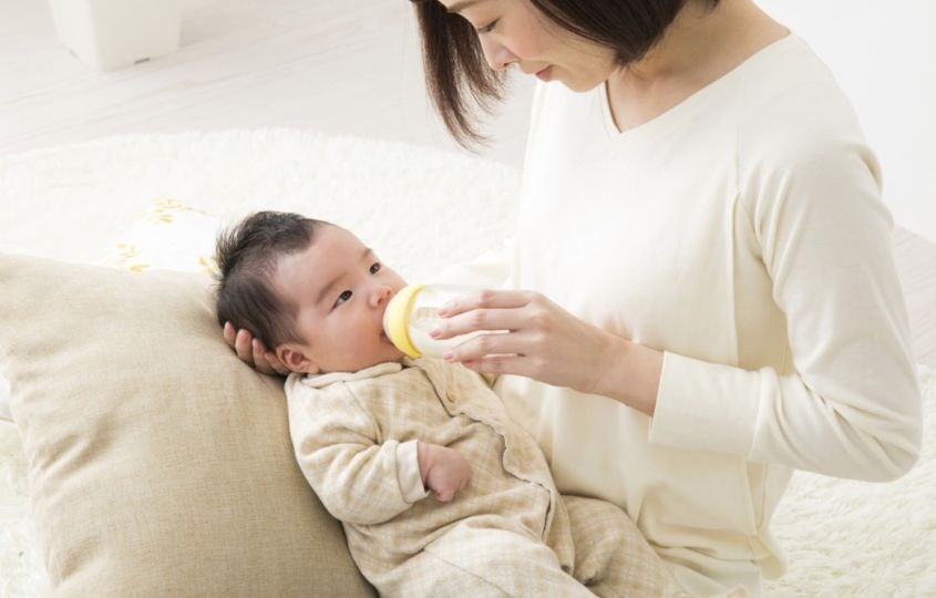 Cầm bình sữa ngang khi cho bé bú