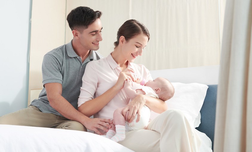 Giữ bình sữa và theo dõi bé trong suốt quá trình bú