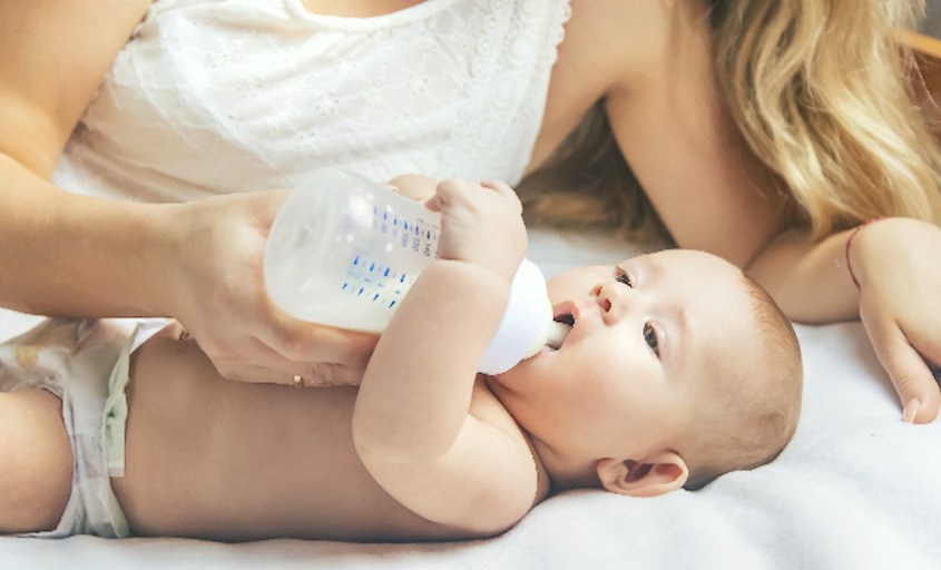 Cho bé bú bình với tư thế nằm ngửa trên giường