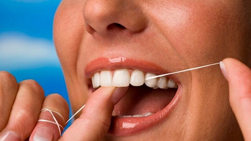 Dùng chỉ nha khoa để loại bỏ mảng bám và thức ăn dễ bị kẹt giữa các răng
