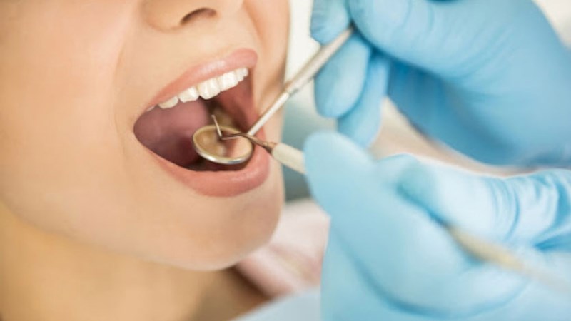 Bác sĩ khám vùng miệng để xác định tình trạng của người bệnh