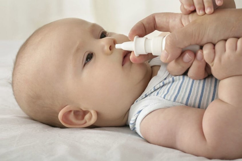 Nhỏ mũi cho bé bằng nước muối sinh lý để cấp ẩm và giúp bệnh viêm phế quản nhanh khỏi