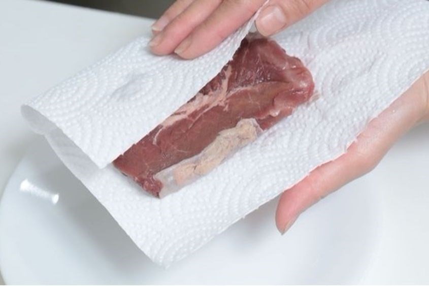 Dùng khăn giấy để thấm bớt nước trên thịt