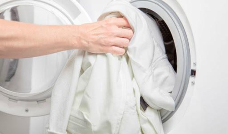 Chọn quần áo cần giặt vào máy giặt và đóng cửa máy giặt chắc chắn