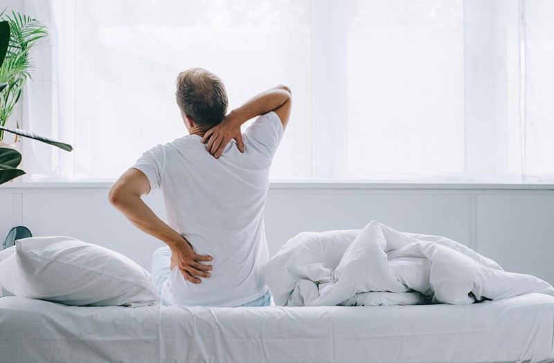 Ngủ nhiều khiến cơ bị tê cứng gây đau lưng