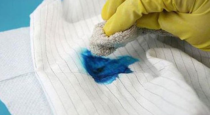 Cạo vết màu ra khỏi quần áo bằng cách đặt áo lên một mặt phẳng và dùng bàn chải để chà sạch vết dính màu