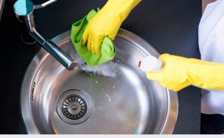 Dùng khăn kết hợp với dung dịch tẩy rửa để làm sạch bồn rửa chén