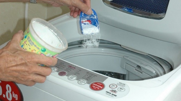 adding detergent into washing machine