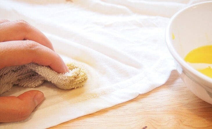Cho hỗn hợp xăng và xà phòng lên vết mực rồi vò nhẹ nhàng để mực tan ra