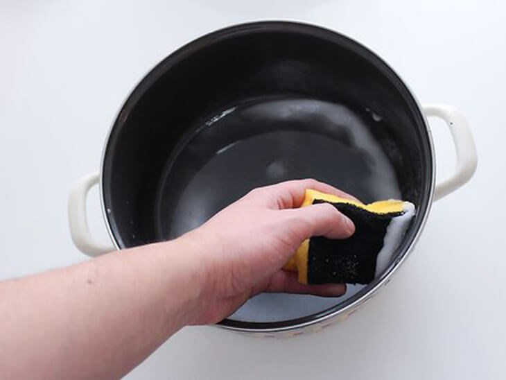 Sử dụng miếng rửa chén để loại bỏ phần cơm còn thừa trong lòng nồi